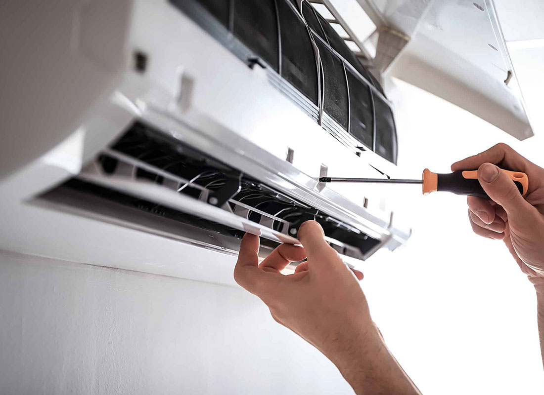 HVAC technician repairing an air conditioning unit in Phoenix, AZ.