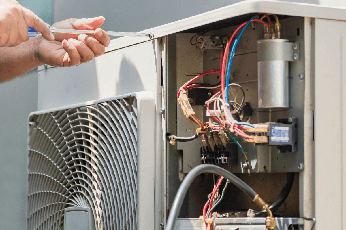 HVAC technician repairing an air conditioning unit in Phoenix, AZ.