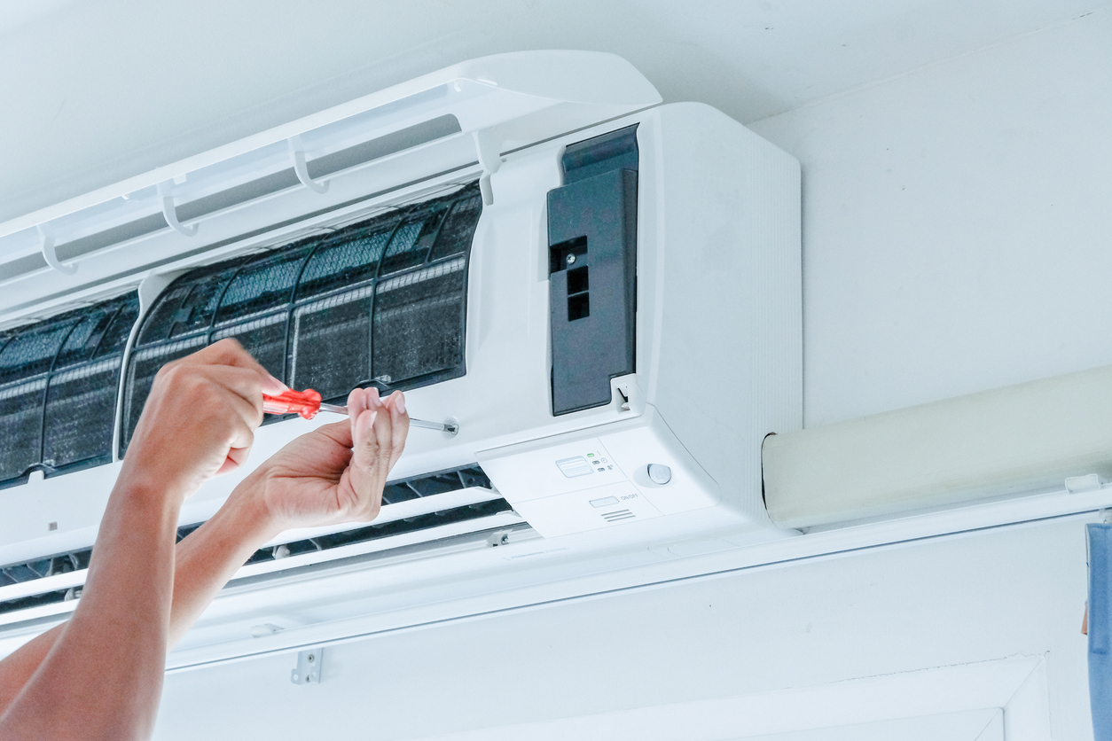 HVAC technician repairing an air conditioning unit in Phoenix, AZ.