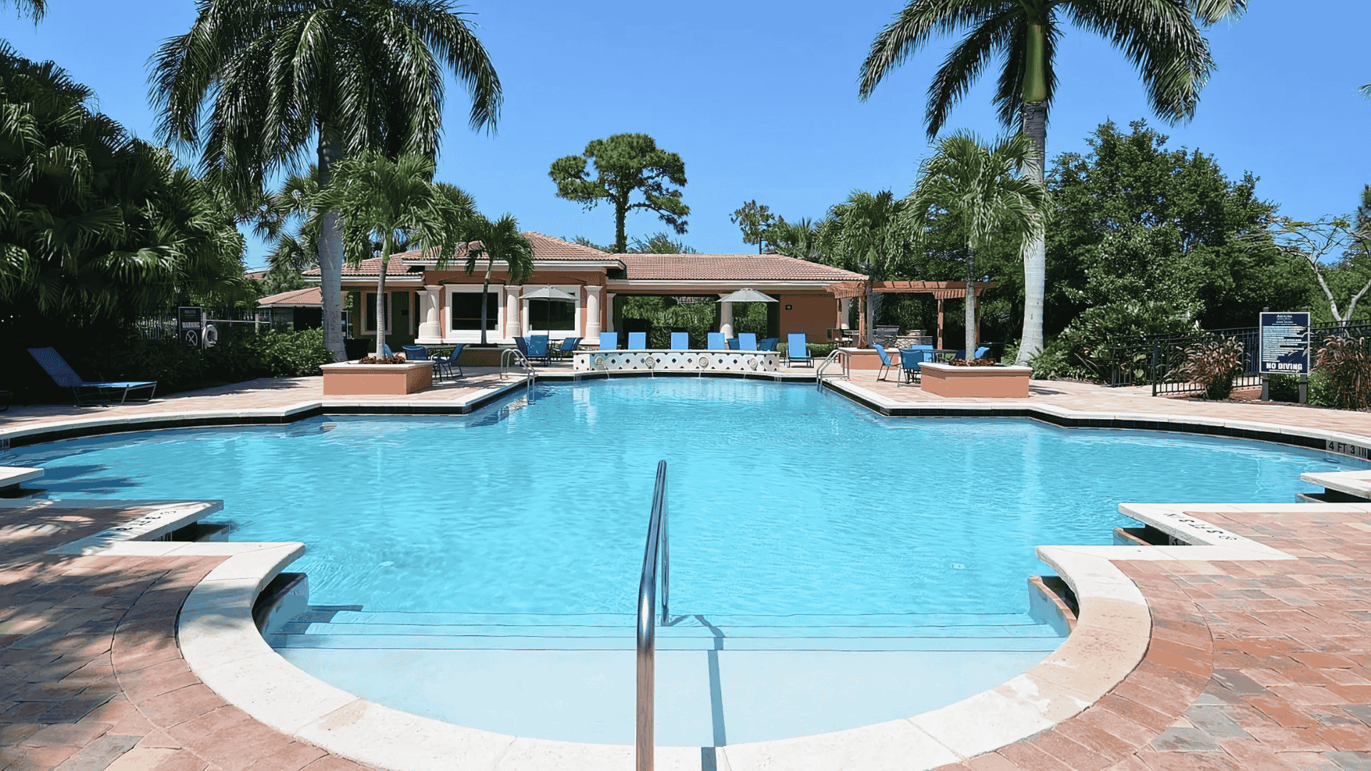 Large community pool with palm-lined deck maintained for commercial clients by Pools USA in Port St. Lucie, FL