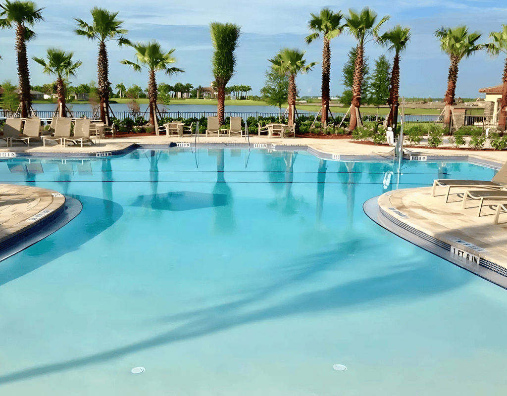 Large community pool with palm-lined deck maintained for commercial clients by Pools USA in Port St. Lucie, FL