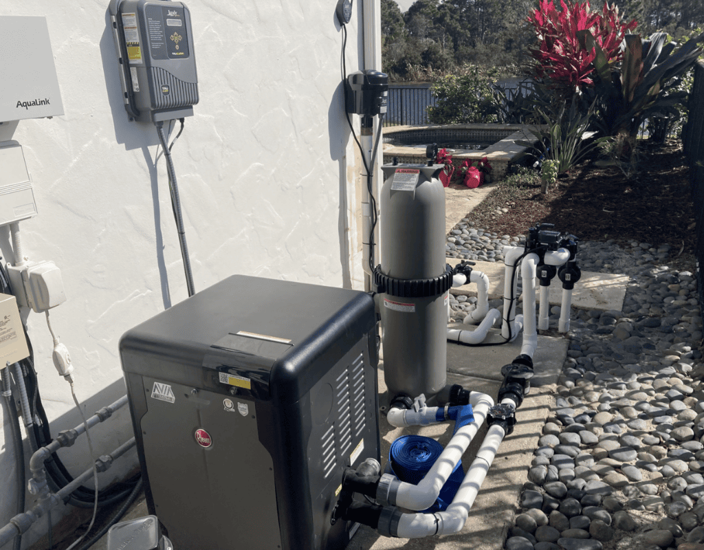 New pool heater, filter tank and plumbing manifold installed against a home exterior by Pools USA technicians in Port St. Lucie, FL.